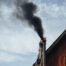 Chimney sweep in New York cleaning a residential chimney on a rooftop, showing risks of DIY chimney cleaning in Brooklyn, Queens, Manhattan, Bronx and Staten Island, with visible black smoke, highlighting the need for professional chimney sweep services in NYC homes and apartments.